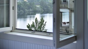 A room with a window overlooking a body of water and a distant landscape. - Vrbo Property (Tui)