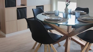 A dining area with a glass table, black chairs, and a wooden bookshelf. - Vrbo Property (Tui)