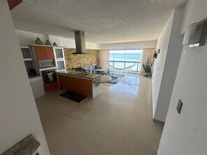 A modern kitchen with a central island, a dining area with a view of the sea, and a living space with a hammock. - Beautiful 2-bedroom apartment with AC in Porlamar (Porlamar)