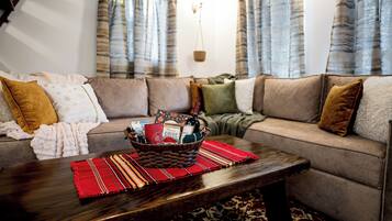 A living room with a sofa set, a coffee table, and a basket of items.