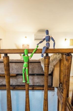 A wooden structure with two figures, one green and one blue, positioned on it.
