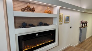 A modern fireplace with a built-in shelf above it, displaying decorative items.