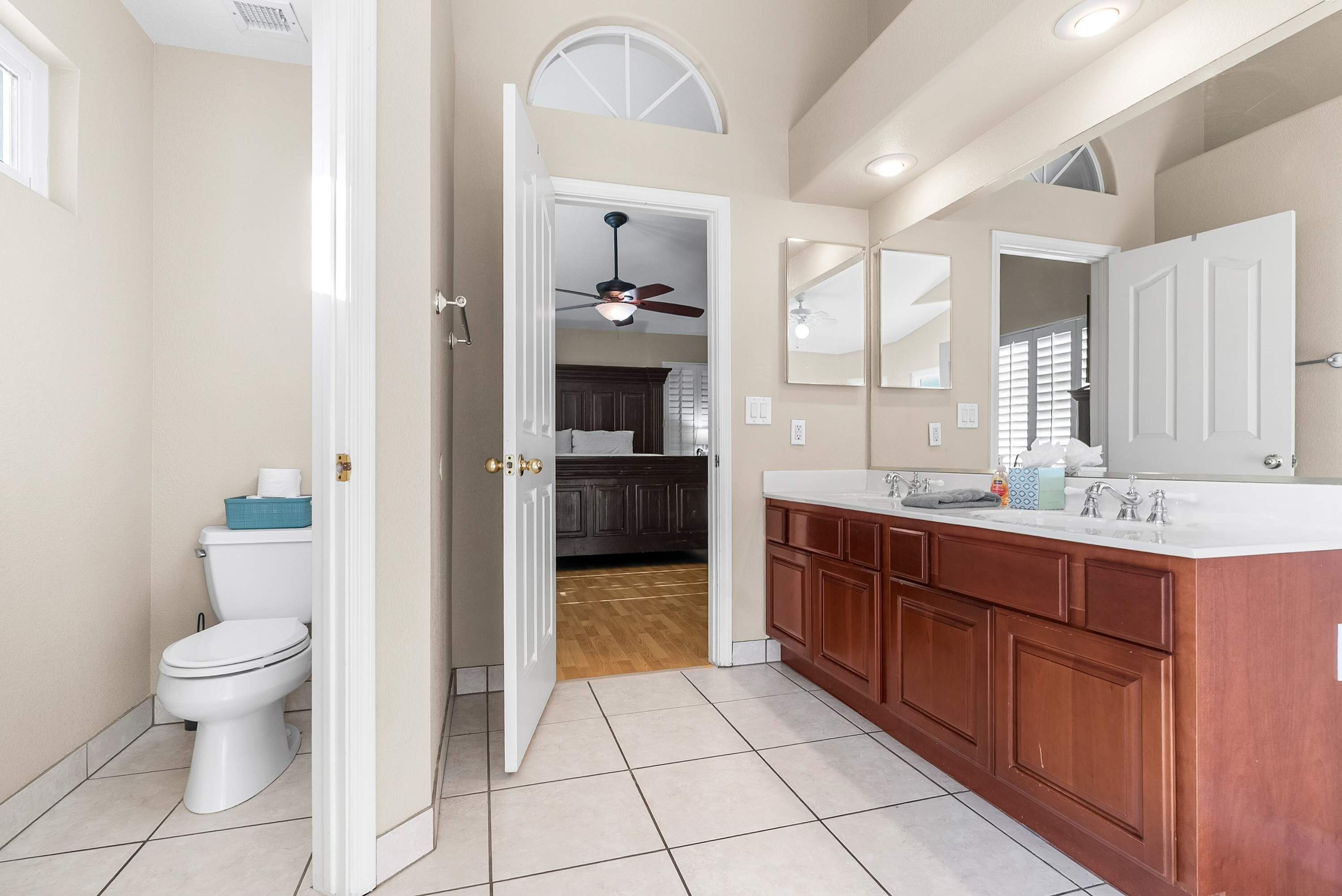 A bathroom with a toilet, a sink, and a mirror.