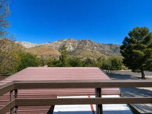 Eine Holzterrasse mit Blick auf eine gebirgige Landschaft.