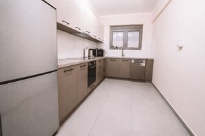 Eine kleine Küche mit Einbauofen, Geschirrspüler und einem Fenster über der Spüle.