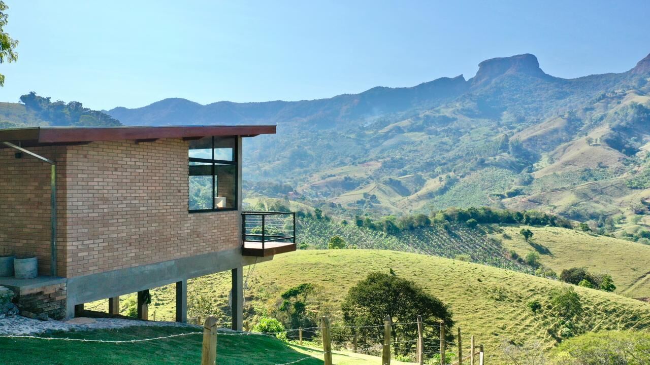 Un edificio moderno con balcón que da a un paisaje montañoso.