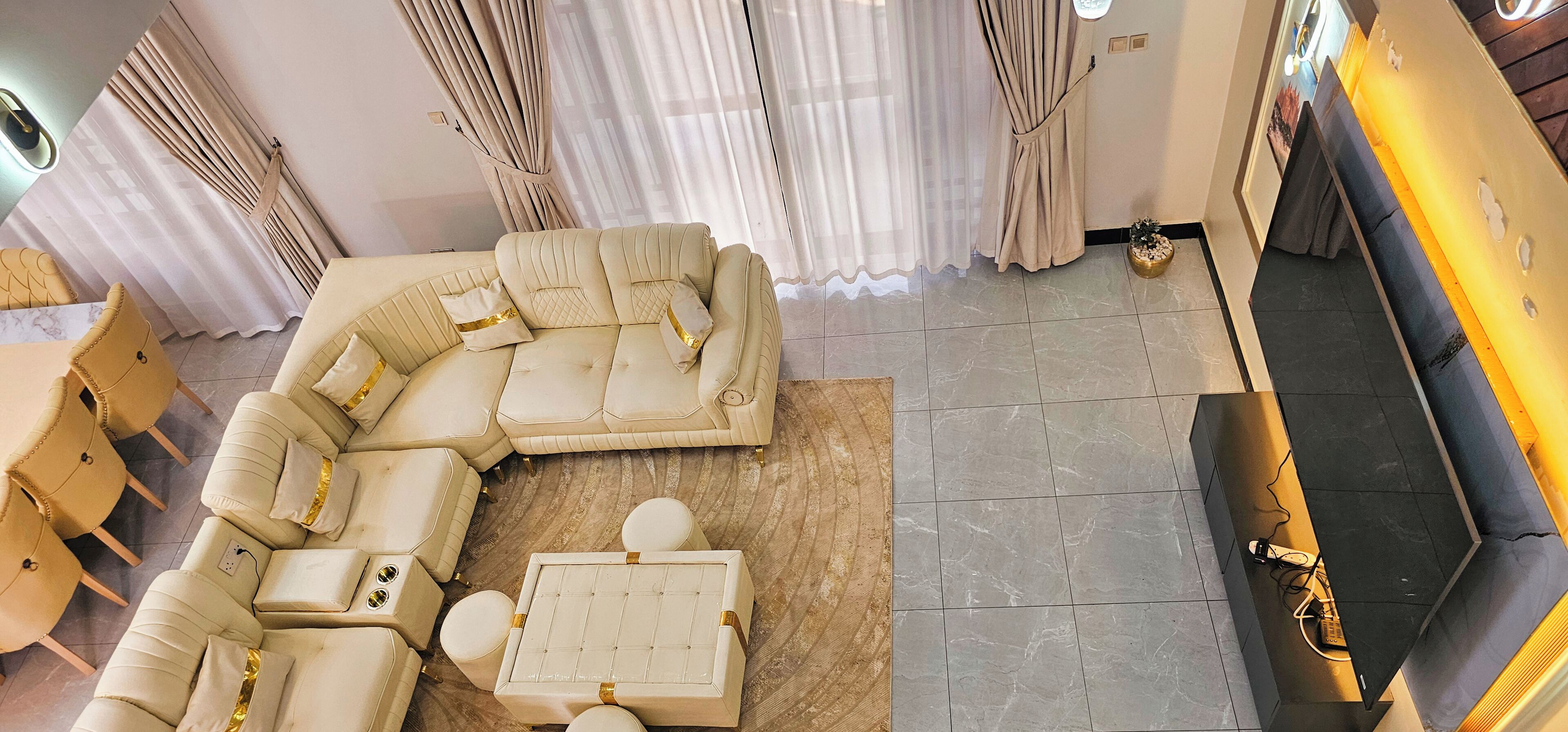 A modern living room with a sectional sofa, a coffee table, and a small ottoman.