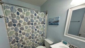 Une salle de bain avec des toilettes, un lavabo et un rideau de douche.