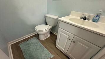 Ein Badezimmer mit Toilette, Waschbecken und Schrank.