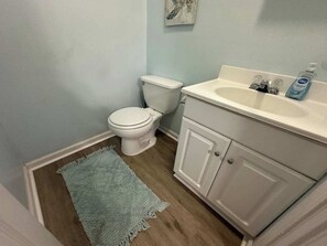 A bathroom with a toilet, a sink, and a cabinet.