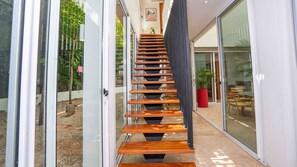 Ein modernes Interieur mit einer Holztreppe, die zu einer Glastür führt.