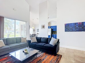 Un salon moderne avec un canapé, une table basse et une vue sur l’extérieur.