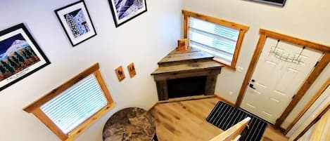 A wooden interior with a fireplace, a dining table, and a view of the outside.