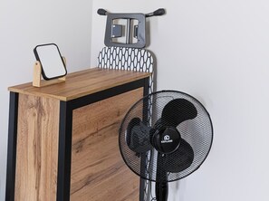 Ein Holztisch mit einem Spiegel in Schwarzrahmen und einem KEPLAND-Ventilator.
