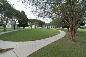 Un parc avec un sentier sinueux, de l’herbe verte et des arbres.