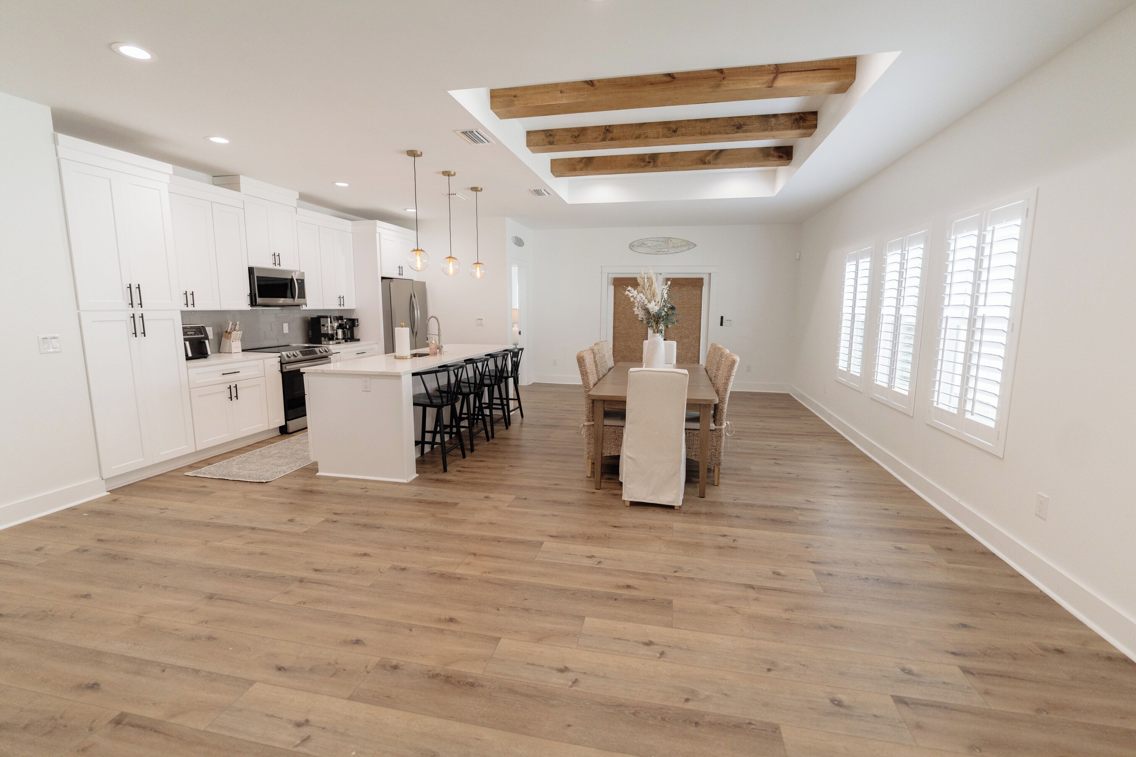 A spacious kitchen with white cabinetry, a central island, and pendant lighting.