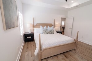 Une chambre à coucher avec un lit en bois, une literie blanche et une table de chevet avec une lampe.