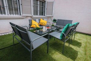An outdoor patio with a table and chairs, a small potted plant, and a bottle. - Villa Zarra, Granada (Maracena)