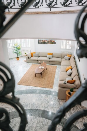 A spacious living room with a large sectional sofa, a coffee table, and a potted plant. - Villa Zarra, Granada (Maracena)