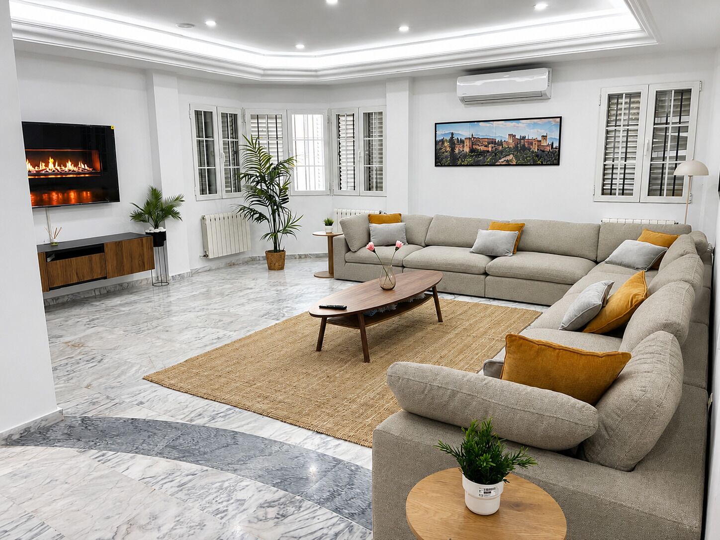 A modern living room with a fireplace, sofa, coffee table, and a TV.