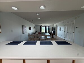 A spacious dining area with a long table, chairs, and a ceiling with recessed lighting. - Spacious 2-bedroom condo with indoor pool and workout room. (Branson)