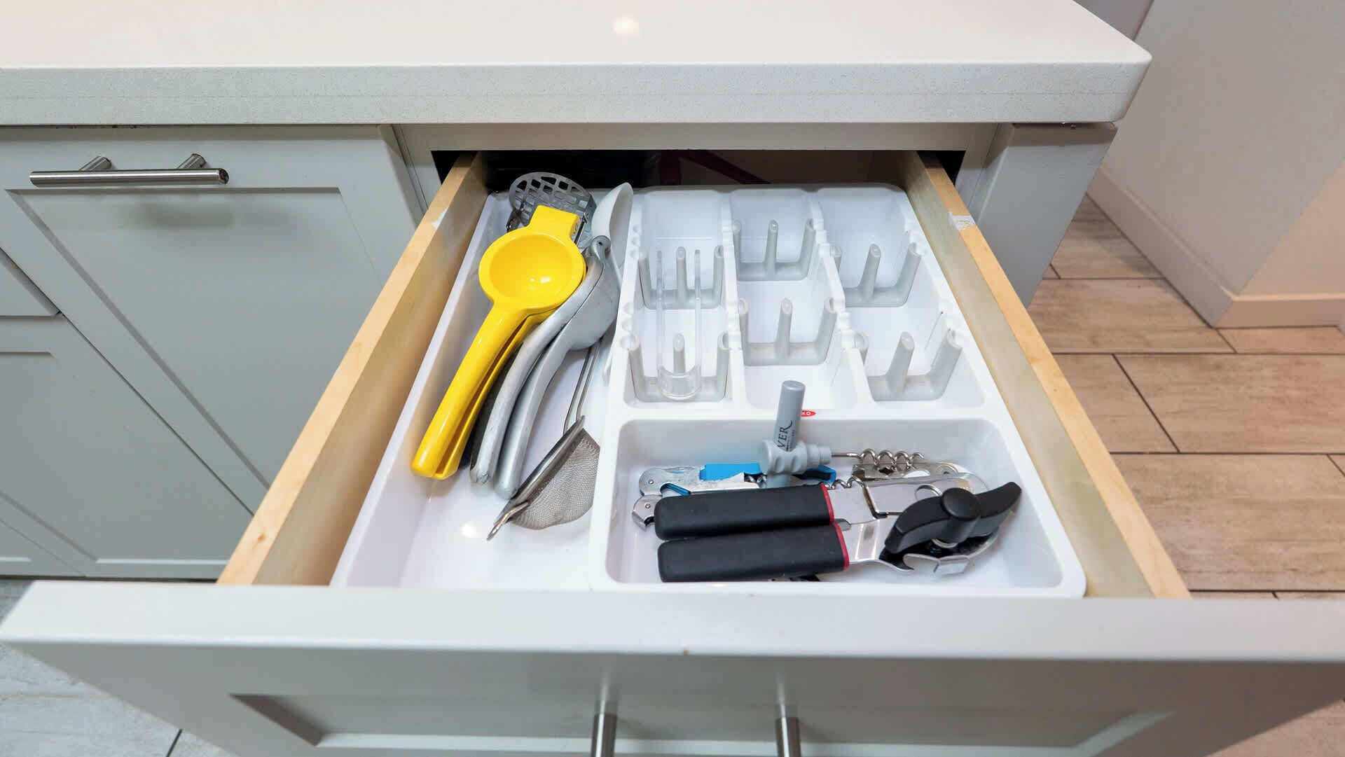 Uma gaveta de cozinha com utensílios e eletrodomésticos.