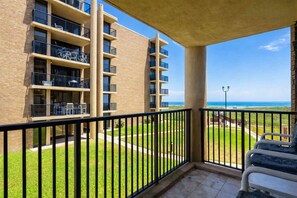 Un balcone con vista su un edificio e l'oceano.