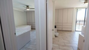 Una stanza con un letto, un armadio e un balcone con vista.