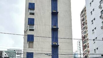 Un edificio alto con fachada de diseño enrejado, múltiples balcones y un cartel que indica 'Lagoa do Abade 1900'.