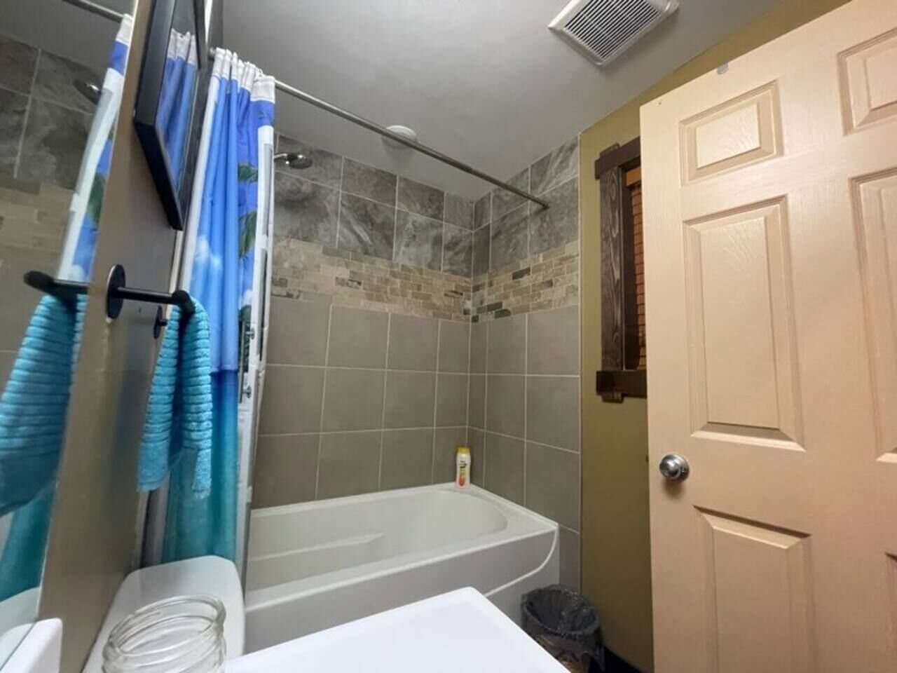 A bathroom with a bathtub, shower, and toilet.