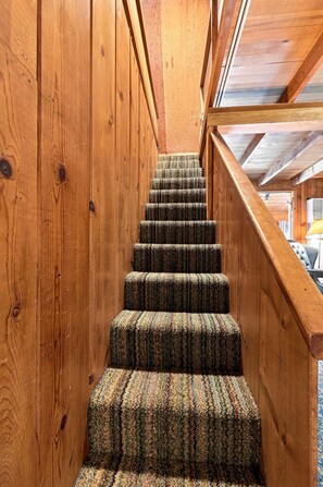 A wooden staircase with carpeted steps leading to a landing. - Cozy Lakeside Cabin: Dock, Deck, & Pet Friendly (McCall)