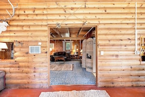 A log cabin interior with a living room, a fireplace, and a dining area. - Cozy Lakeside Cabin: Dock, Deck, & Pet Friendly (McCall)