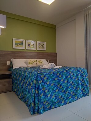 A hotel room with a bed, green walls, and three framed pictures on the wall. - Malawi Muro Alto, ground floor apartment (N. Sra. do Ó)