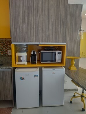 A compact kitchenette with a microwave, coffee maker, and two mini refrigerators. - Malawi Muro Alto, ground floor apartment (N. Sra. do Ó)
