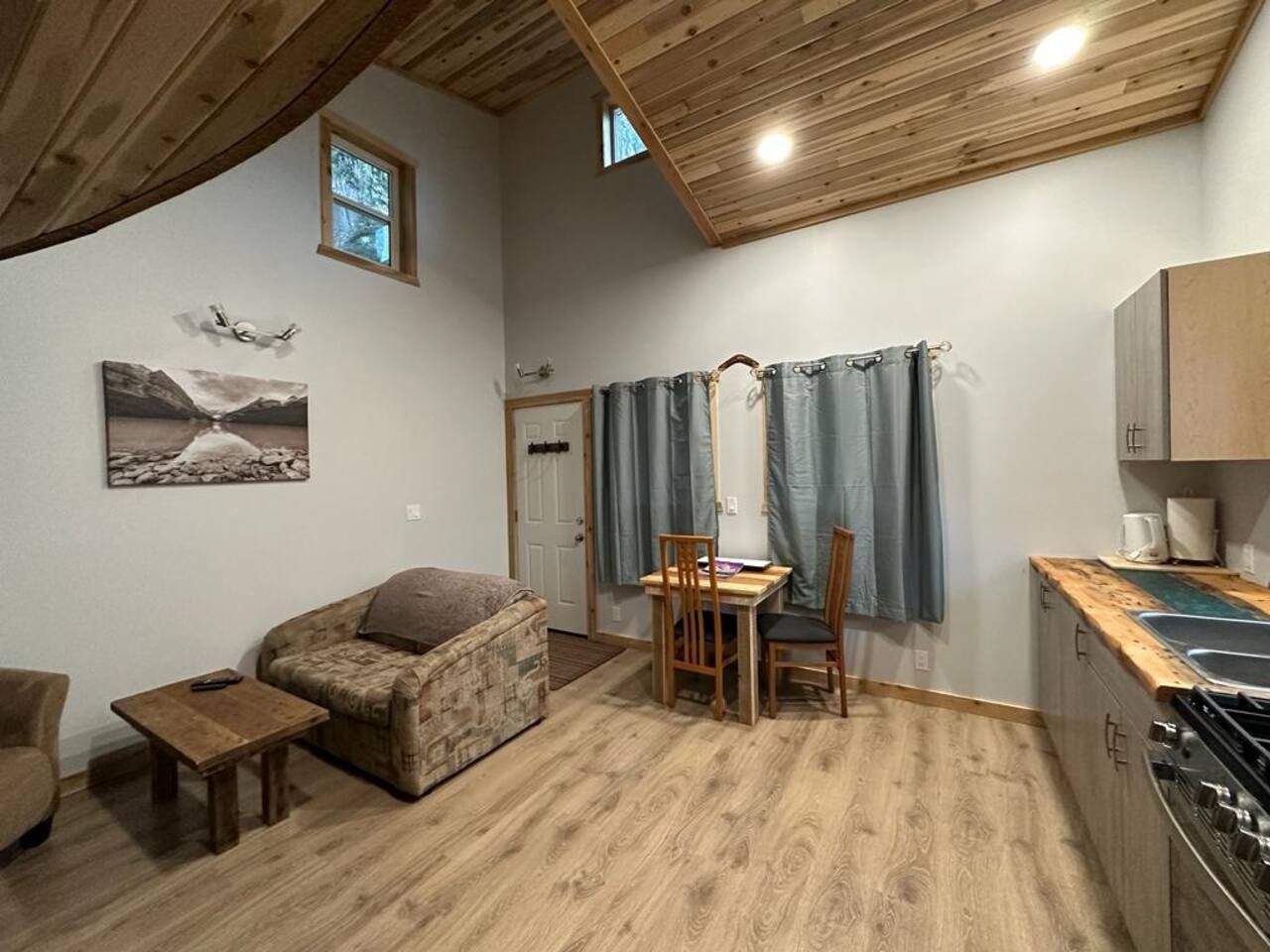 A compact living space with a kitchenette, a dining area, and a sofa.