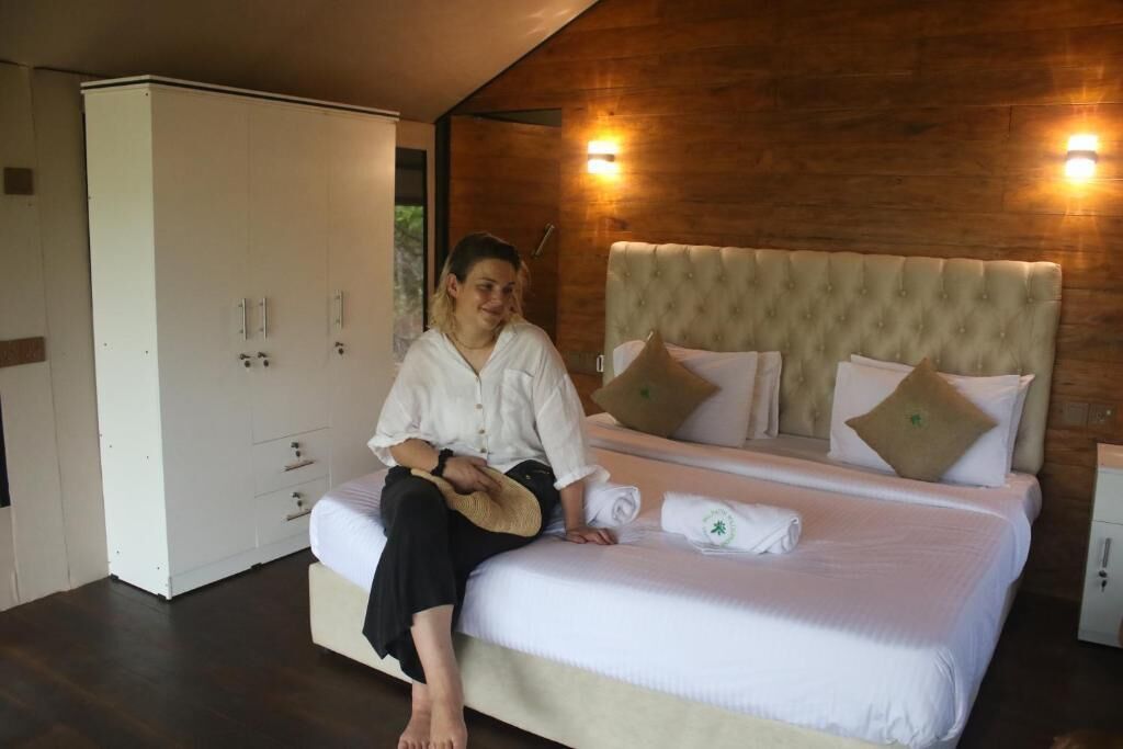 A room with a bed, a wardrobe, and a wall-mounted light fixture.