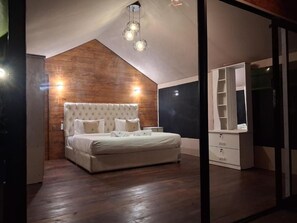 A bedroom with a large bed, a wardrobe, and a ceiling light fixture. - Wilpattu Wilderness Camping - Deluxe Double Room -2 Adults + 1 Child- (Wilpattu)
