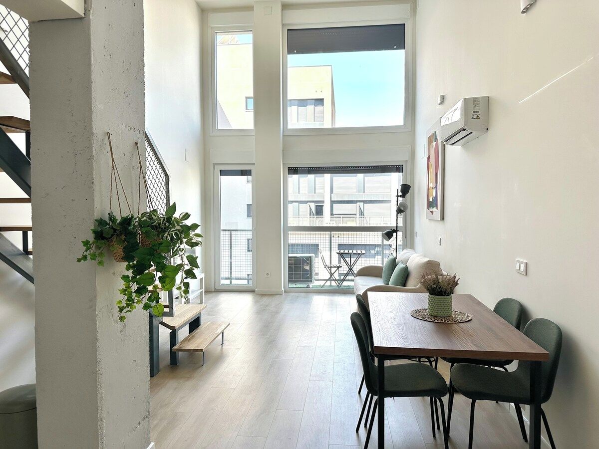 Een modern interieur met een eethoek, een trap en uitzicht op buiten.
