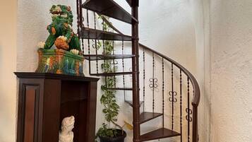 A spiral staircase with a wooden handrail and a black metal railing.