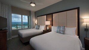 A hotel room with two beds, a large window with a view of the ocean, a ceiling fan, and a TV on a stand. - Oceanfront Elegance Awaits – Discover Family Fun at Marriott’s Oceana Palms! (Riviera Beach)