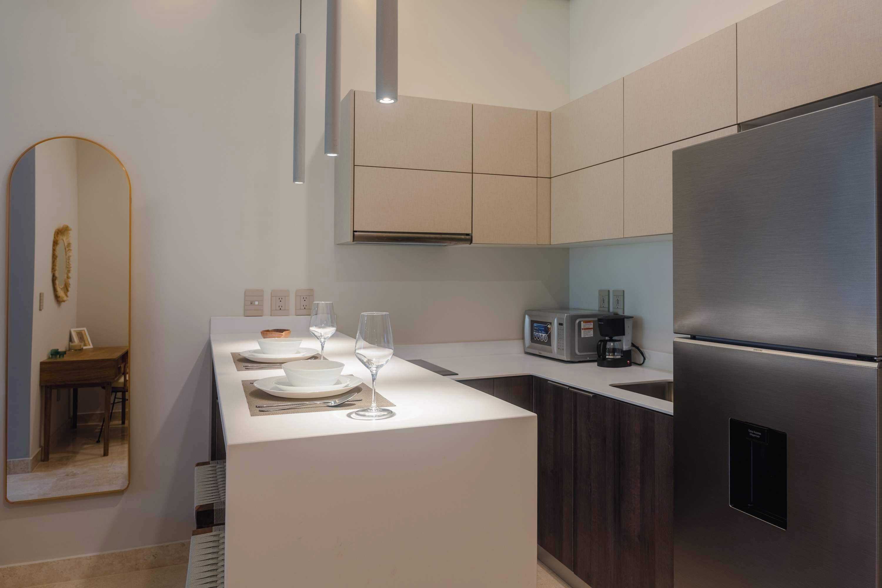 A modern kitchen with a stainless steel refrigerator, a microwave, and a coffee maker on the counter.