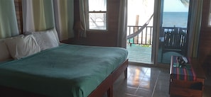 Une chambre à coucher avec un lit, une fenêtre et une vue sur l’océan.