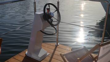 Une plateforme en bois avec un volant et deux chaises longues vides.
