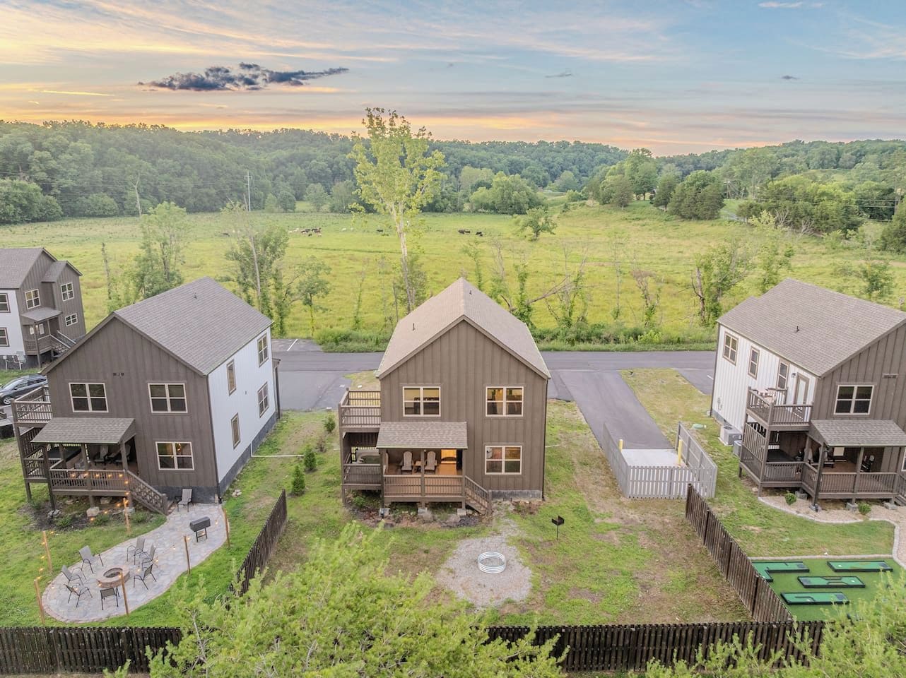 A residential area with three houses, each featuring a deck and outdoor seating.