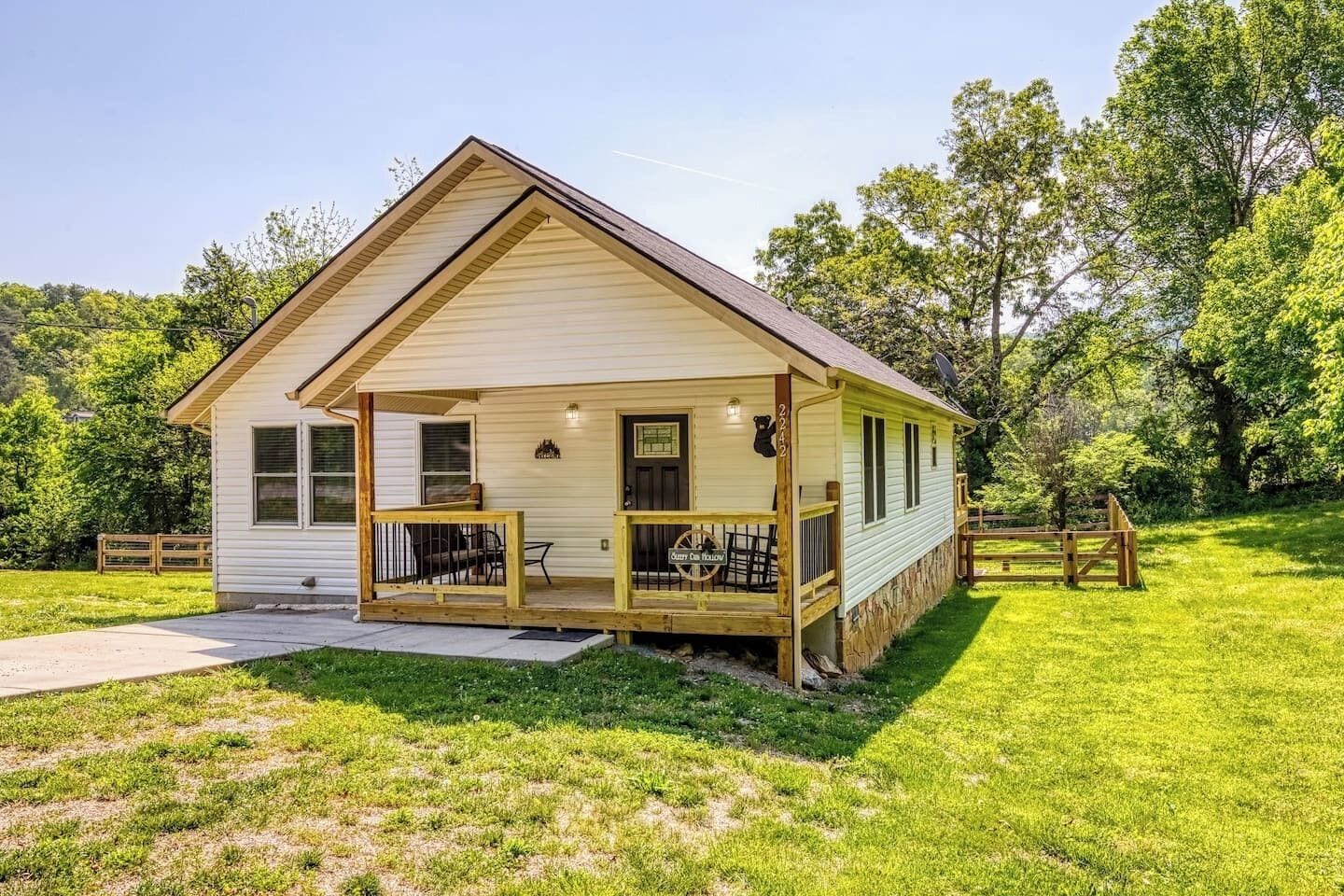 A single-story house with a porch, a small deck, and a mailbox.