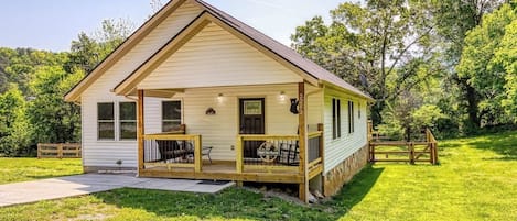 A single-story house with a porch, a small deck, and a mailbox.