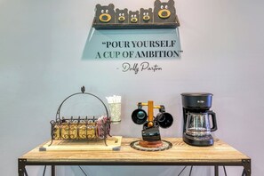 A coffee station with a quote sign, a coffee maker, and a decorative item. - Sleepy Cub Hollow! Dollywood | Fenced In | Hot Tub (Sevierville)