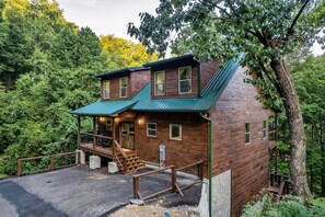 Une cabane en bois avec une véranda, un escalier et une zone délimitée par une clôture.