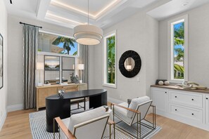 A modern interior with a dining area, a black console table, a white sofa, and a view of palm trees through large windows. - NEW! Waterfront Luxury - Pool, Spa & Bay Views (Naples)