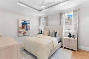 A bedroom with a bed, bedside tables, a ceiling fan, and a painting on the wall. - NEW! Waterfront Luxury - Pool, Spa & Bay Views (Naples)